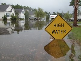 Flood in neighborhood with a sign saying High Water