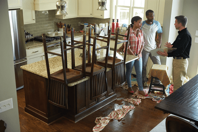 Service Master Restore professional reviewing kitchen flood damage repairs with customers